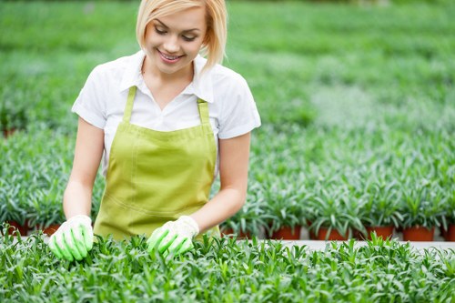 Operative wearing PPE while using a powered hedge cutter